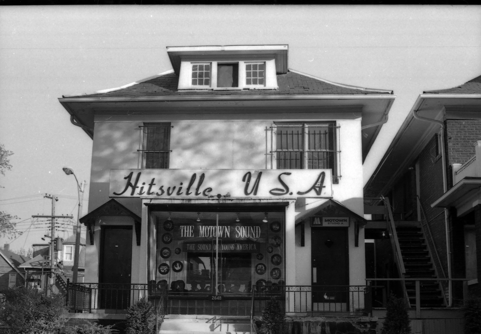 A solidly build residence has a sign reading 'Hitsville USA' across the facade.