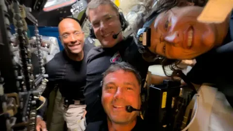 NASA Reid Wiseman, Victor Glover, Christina Koch and Jeremy Hansen pose for a selfie in the spacecraft